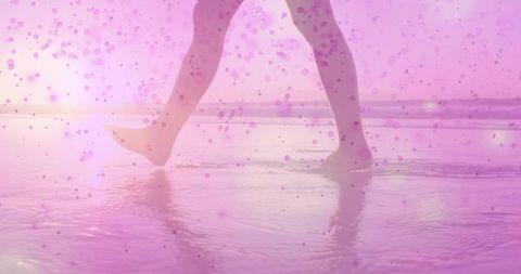 Feet walking through waves at beach with pink overlay