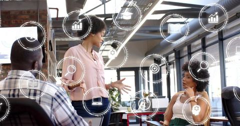 Team presenting and collaborating in modern industrial office with floating data icons