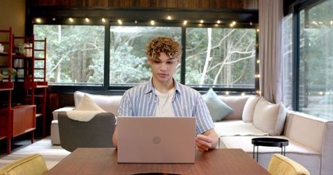 Young professional working in cozy modern living space with laptop