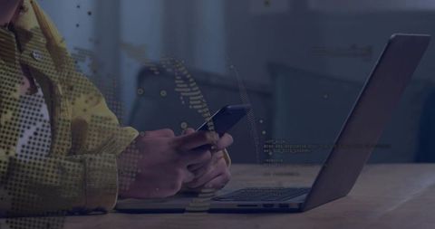 Woman in yellow jacket using smartphone at laptop with digital code overlay for remote work