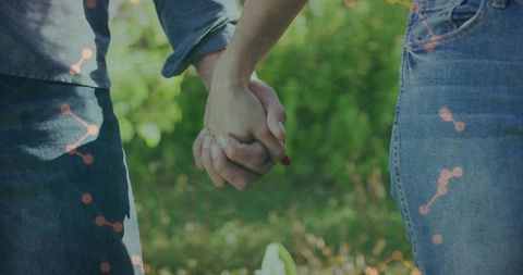 Couple Holding Hands in Garden Wearing Denim