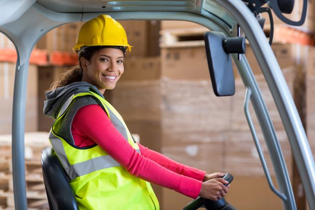 Portrait of warehouse worker using a forklift in warehouse