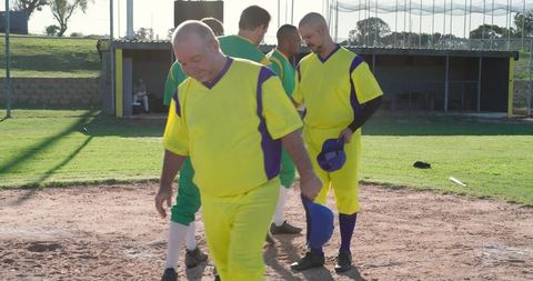 Adult softball team walking off infield holding caps showing sportsmanship after game