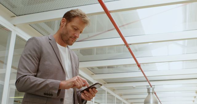 Businessman Using Smartphone in Bright Modern Office - Download Free Stock Images Pikwizard.com