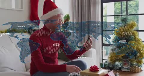 Man Wearing Santa Hat Making Holiday Video Call with Global Network Overlay in Cozy Living Room