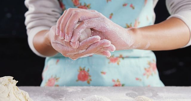 Hands are forming dough balls with flour. Useful for illustrating homemade cooking, baking recipes, culinary blogs, kitchen-themed advertisements, and DIY baking tutorials.