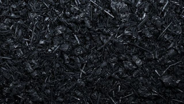 Glossy black shredded plastic texture macro background for industrial design and packaging