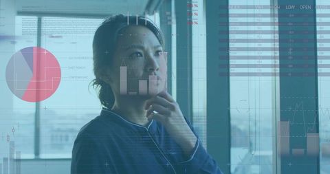 Businesswoman analyzing financial dashboards through window with city skyline data overlay