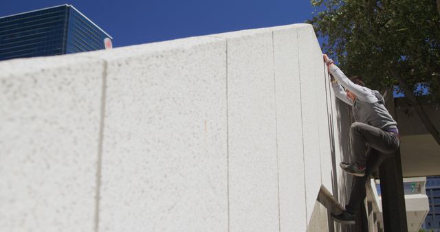 Young adult climbing urban concrete wall with determination - Download Free Stock Images Pikwizard.com