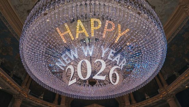 Grand ornate crystal chandelier sparkling over domed ballroom featuring happy new year 2026