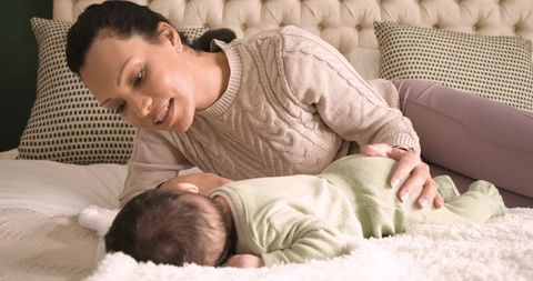 Mother Bonding with Baby on Bed in Cozy Home Environment