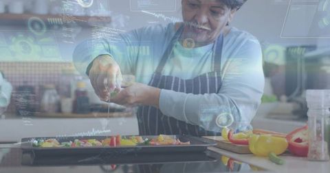 Senior cook squeezing citrus over colorful vegetable tray with futuristic digital hud