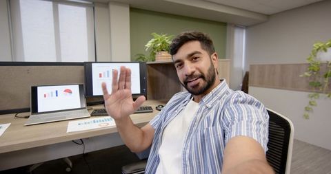 Employee Waving on Videocall at Modern Workspace