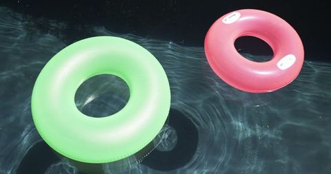 Colorful swim rings floating in clear pool water