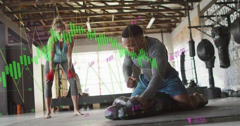 Trainer kneeling over partner in garage gym with boxing gear and live data overlay