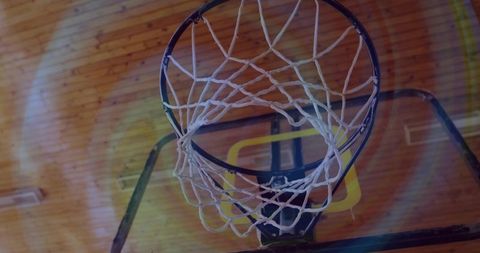 Basketball hoop under gym ceiling with fluorescent lights