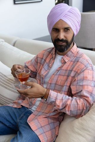 Indian Man Relaxing with Tea in Modern Living Room