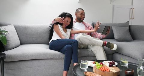 Engaged couple video calling to share happy news at home