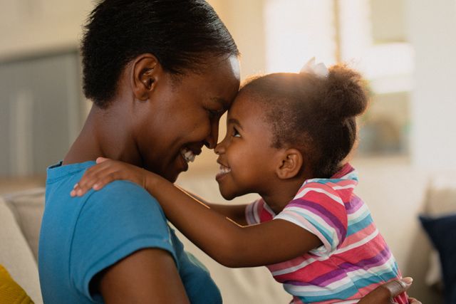 Portrait of happy african american mother and daughter hugging. family, spending time together at home.