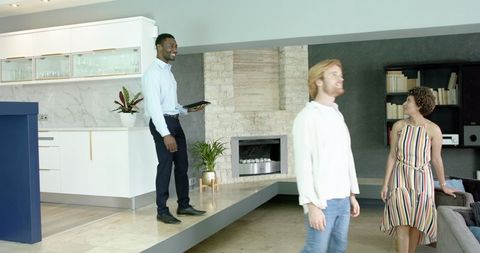 Couple Touring Modern Home with Realtor Using Tablet