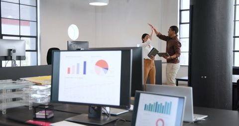 Diverse Colleagues Celebrating Success in Contemporary Office