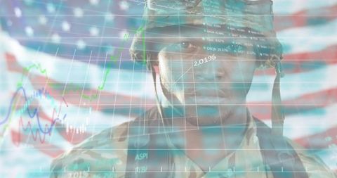 Stoic soldier standing before american flag with stock market charts overlay