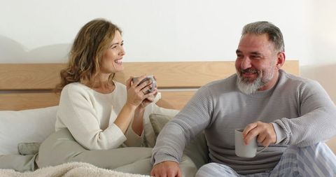 Mature Couple Enjoying Morning Coffee in Bed, Cozy Intimate At-Home Moment