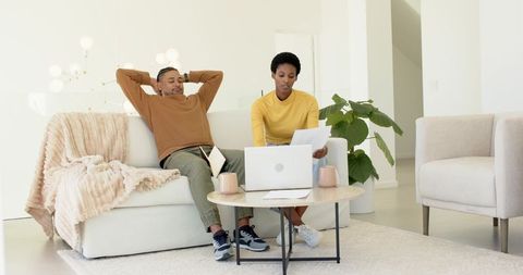 Modern Couple Collaborating at Home with Laptop and Documents