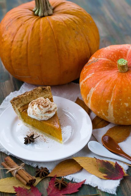 Pumpkin pie with cinnamon and whipped cream on rustic wood table - Download Free Stock Photos Pikwizard.com