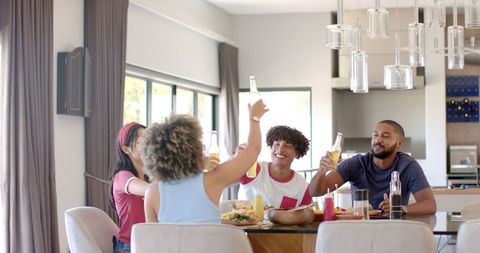 Diverse group of friends toasting at dining table during meal