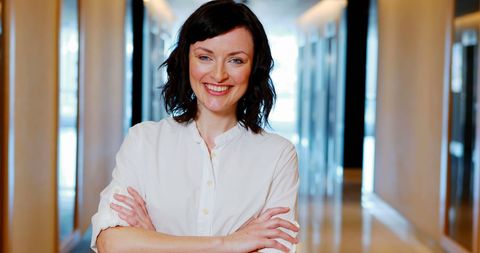 Confident Female Executive Standing in Office Corridor