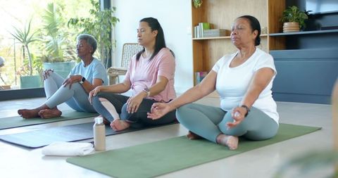 African american women seniors practicing mindful yoga at home with natural light