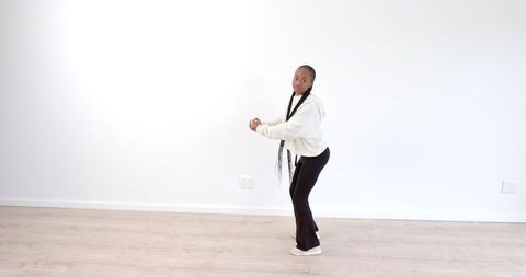Focused Woman Practicing Squats in Bright Minimalist Room