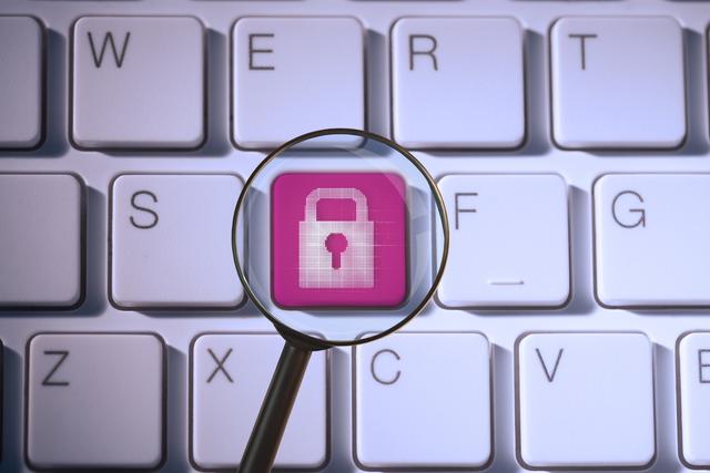 Padlock symbol on keyboard viewed through magnifying glass is illustrating concepts of cybersecurity and data protection. Ideal for use in articles, blogs, and presentations focusing on internet security, online safety measures, and IT security practices.