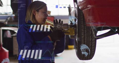 Woman technician torquing wheel using impact gun on lift with augmented reality overlays