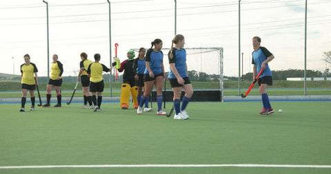 Women playing field hockey with focus and team spirit