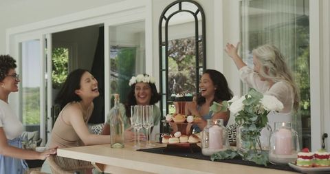 Joyful Women Celebrating with Desserts and Floral Decor at Home Gathering