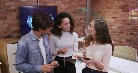 Coworkers Discussing Blueprint in Creative Modern Workspace