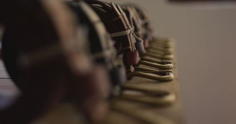 Close-up of leather belts lined in artisan workshop