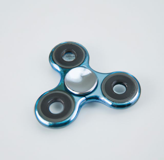 The blue metallic fidget spinner with black bearings lies flat on a white background. This vibrant fidget toy is perfect for articles or advertisements about stress relief, focus improvement, or contemporary trends in desk toys. Use in promotional materials aimed at those who enjoy trendy, small, portable toys that provide relaxation or distraction.