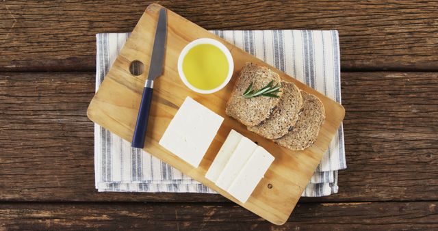 Rustic Cheese Board with Bread Slices, Olive Oil and Knife on Wood Table - Download Free Stock Images Pikwizard.com
