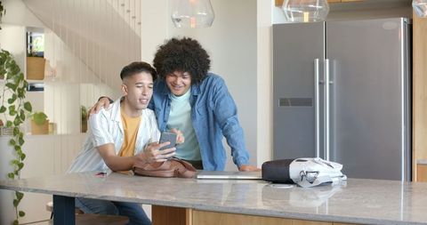 Diverse Friends Using Technology in Modern Kitchen