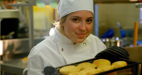 Smiling Female Chef Presenting Freshly Baked Cookies in Professional Kitchen - Download Free Stock Images Pikwizard.com