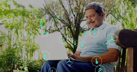Senior man working on laptop in sunlit park with green tech icons and serene greenery