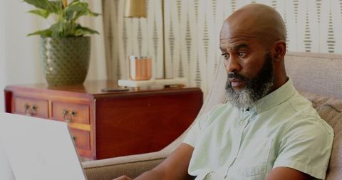 Man with Beard Working on Laptop at Home Office Environment