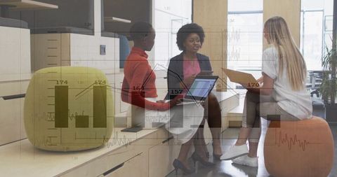Business team collaborating with laptop and overlaying analytics in modern office lounge