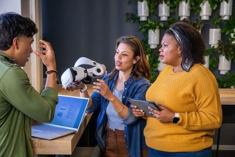 Diverse team testing vr headset for collaborative design and demo in modern workspace