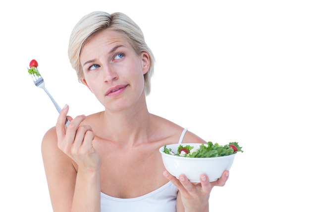 Caucasian blonde woman looks thoughtful while holding a fork with one hand and a bowl of fresh salad in the other hand standing against a transparent background. Ideal for promotions regarding healthy eating, nutrition tips, lifestyle blogs, wellness programs, diet advertisements, and articles about healthy eating habits.