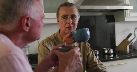 Senior Couple Enjoying Coffee Conversation in Modern Kitchen