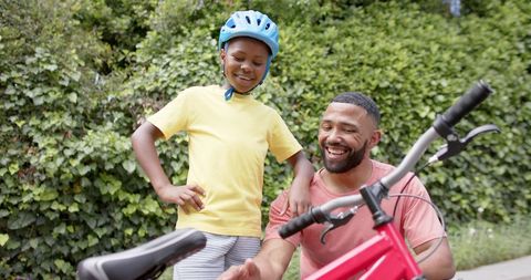Father Teaching Son About Bicycle Outdoors, Enjoying Time Together